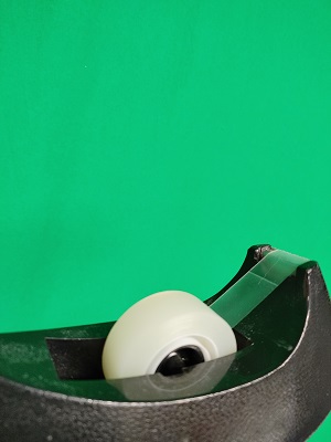 Tape dispenser in front of green screen cloth