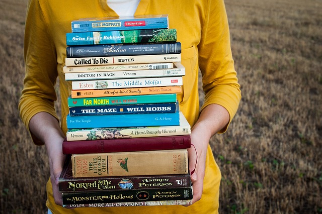 Person holding a stack of books