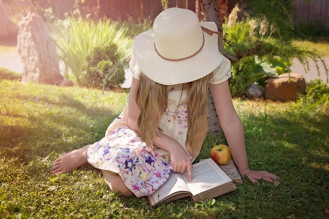 Woman sitting on grass reading a book